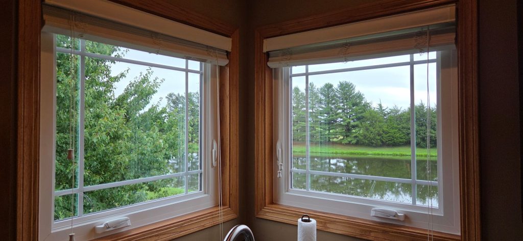Wooden window seats overlooking a green pond and trees outside