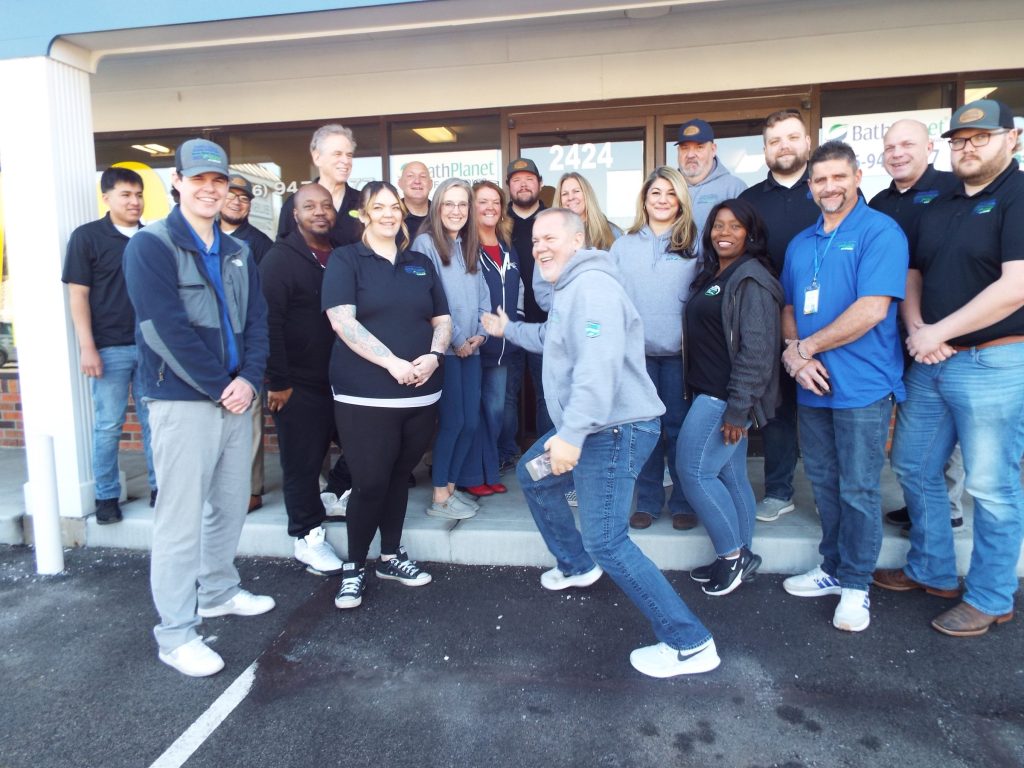 The Perfect Choice Home Solutions Peoria team, about twenty managers and staff in company polos, jackets and caps, gathered outside the Peoria office.