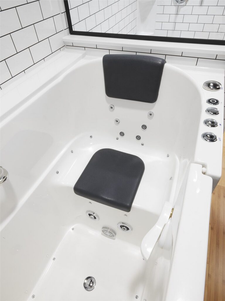 Inside a white walk-in tub: a built-in seat and headrest with rows of massage jets along the sides.